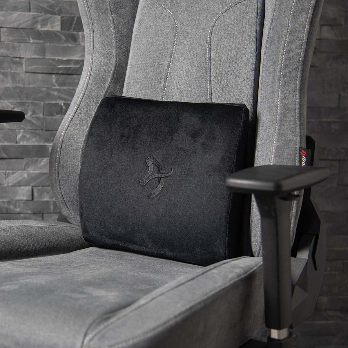 Arozzi Europe Lumbar Support Pillow Velvet Black on gray ergonomic chair, stone wall background.