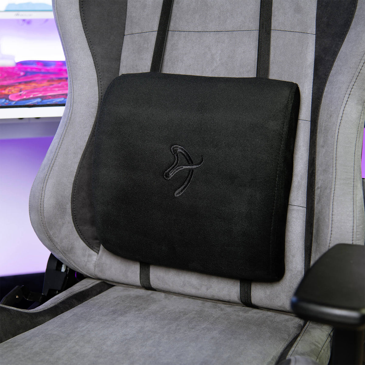 Arozzi Europe Lumbar Support Pillow Velvet Black on gray gaming chair at desk with pink lighting.