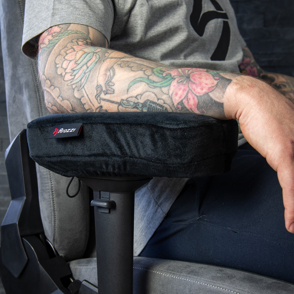 Tattooed arm on Arozzi Europe Memory Foam Armrest Pads attached to a chair.