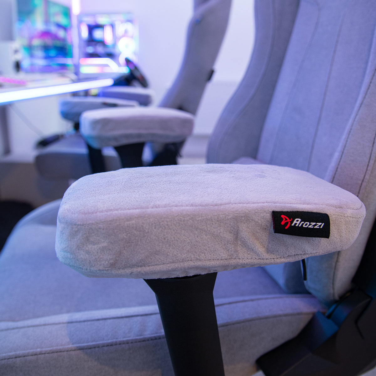 Close-up of a gray Arozzi Europe chair with Memory Foam Armrest Pads in a gaming setup.