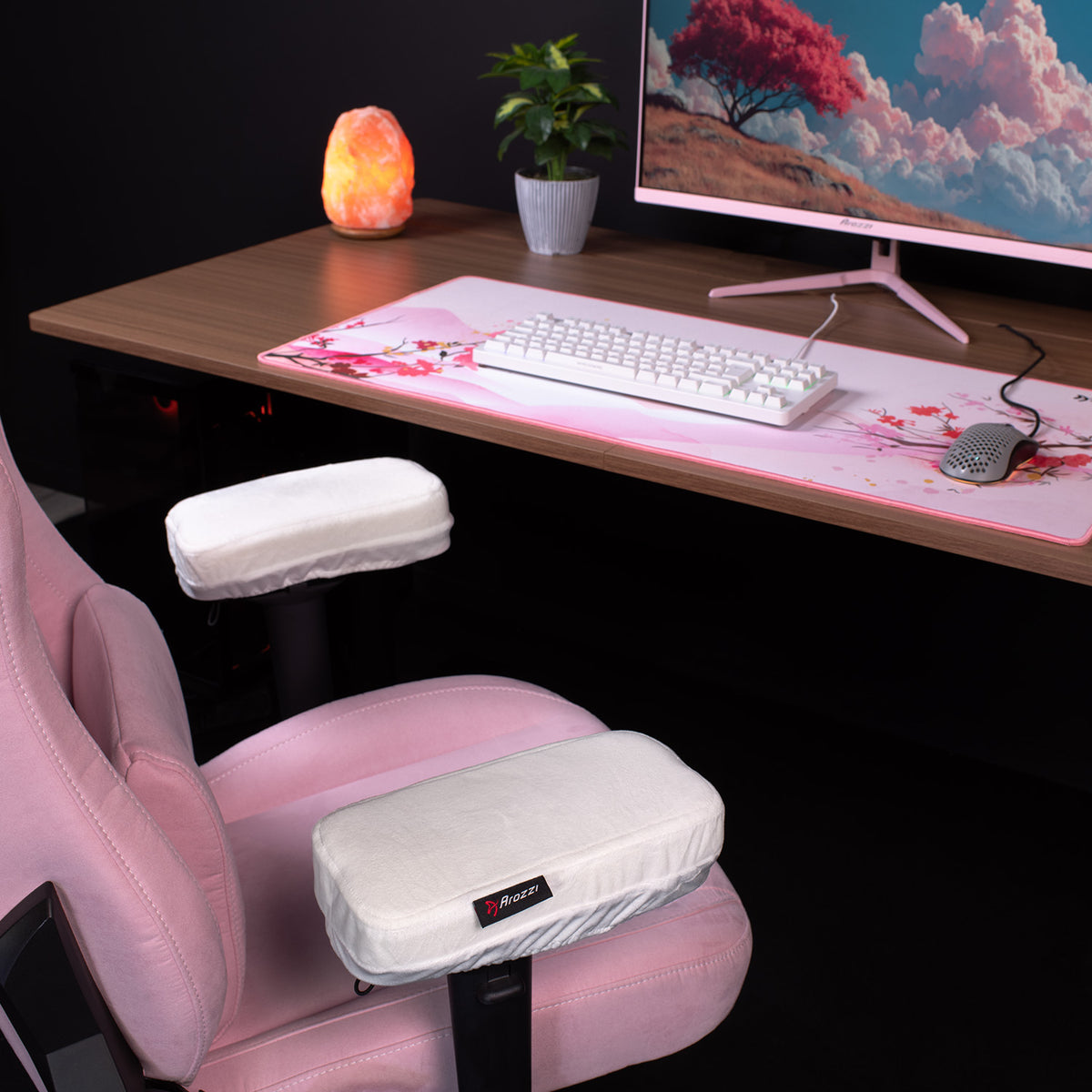 Pink gaming chair with Arozzi Europe Memory Foam Armrest Pads by desk, monitor, keyboard, and lamp.