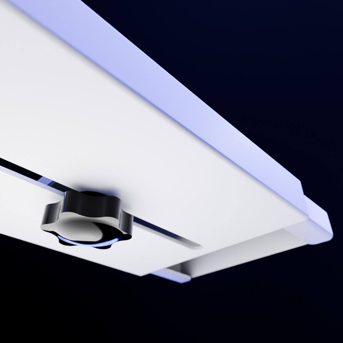 Close-up of a white panel with a black knob, viewed from below against a dark background.