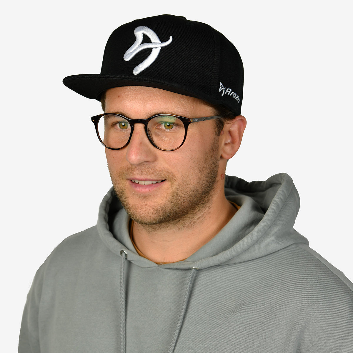 Man in glasses and gray hoodie wears an Arozzi Europe Snapback Cap with white front logo.