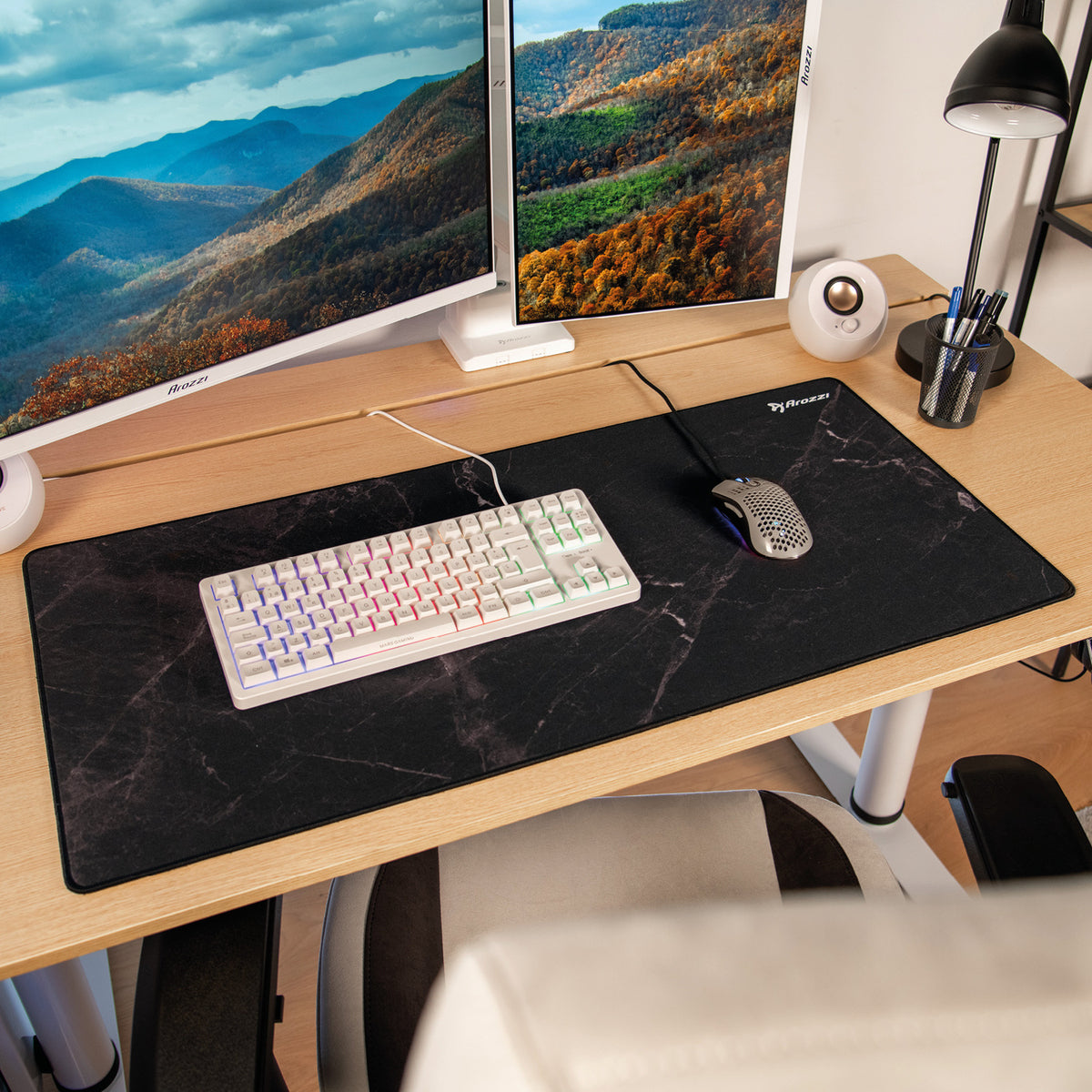 Desk with Arozzi Europe Zona Mousepad XL, speakers, dual monitors, and a landscape wallpaper.