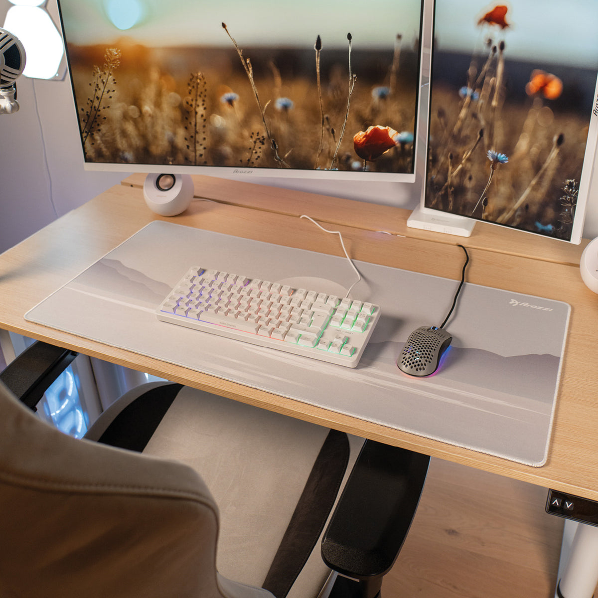 Desk with Zona Mousepad by Arozzi Europe and dual monitors showing wildflowers.
