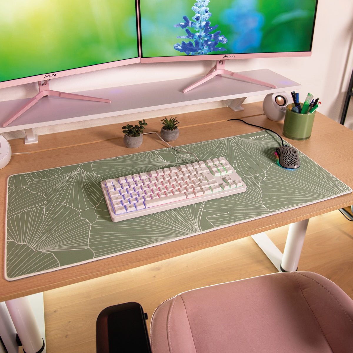 Dual monitors, pink chair, and Zona Mousepad - Extra Large by Arozzi Europe on wood floor.