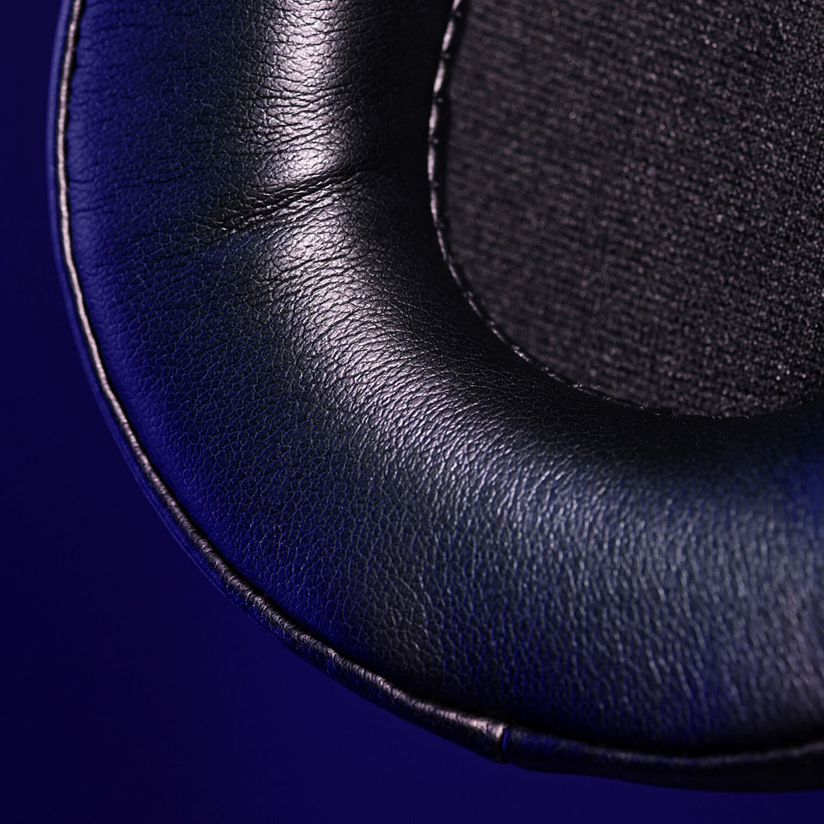 Close-up of a black leather headphone ear cushion with visible stitching.