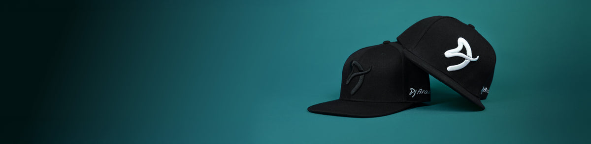 Two black caps with white and black embroidered logos on a teal background.