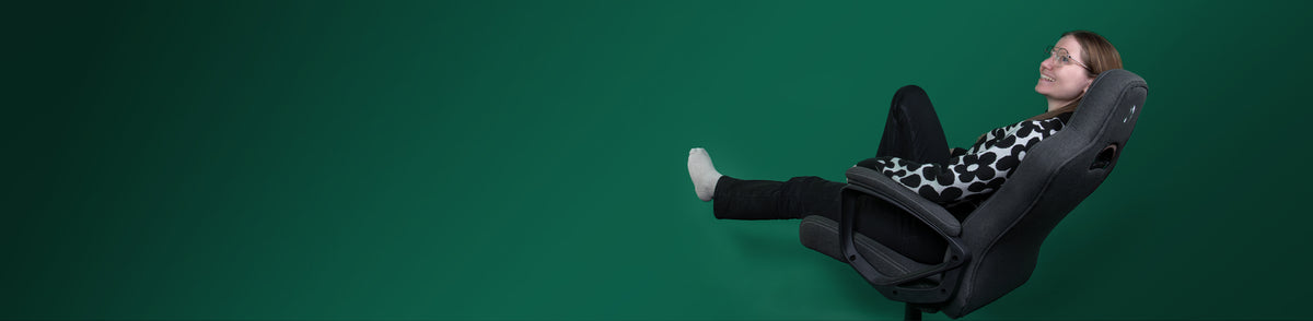 Woman relaxing in an office chair, legs up, with a green background.