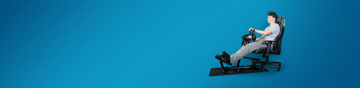 Person in a chair using a driving simulator on a solid blue background.
