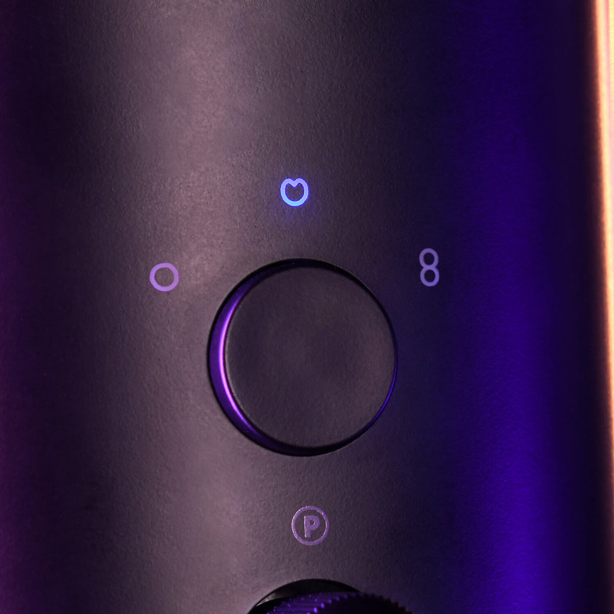 Close-up of a microphone dial with glowing purple mode icons on a dark background.