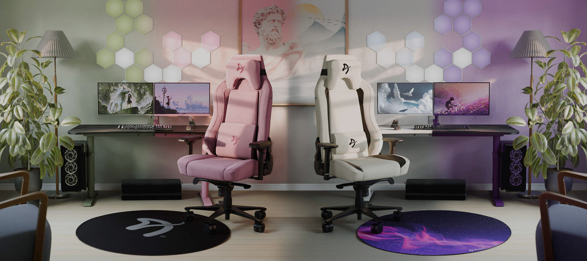 Two gaming chairs and desks with computers in a pastel, modern room with plants and wall art.
