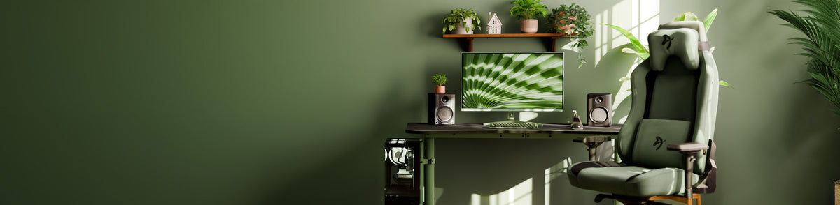 Modern green-themed workspace with a desk, computer, speakers, and plants.