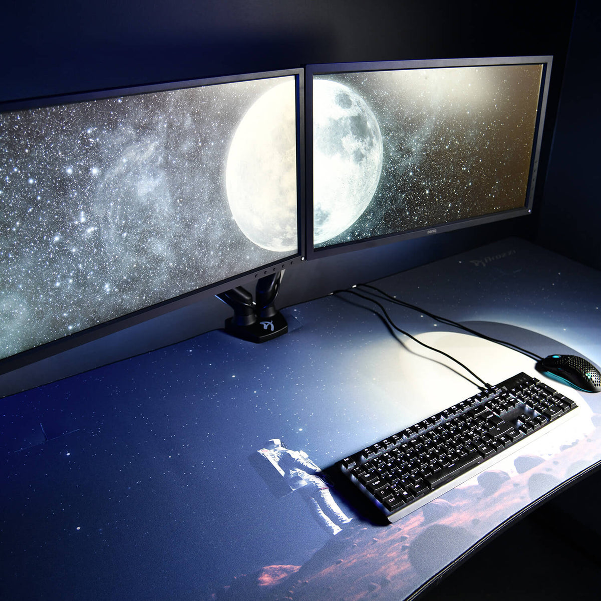 Dual monitors; Arozzi Europe Arena Mousepad with astronaut, planet; keyboard and mouse visible.