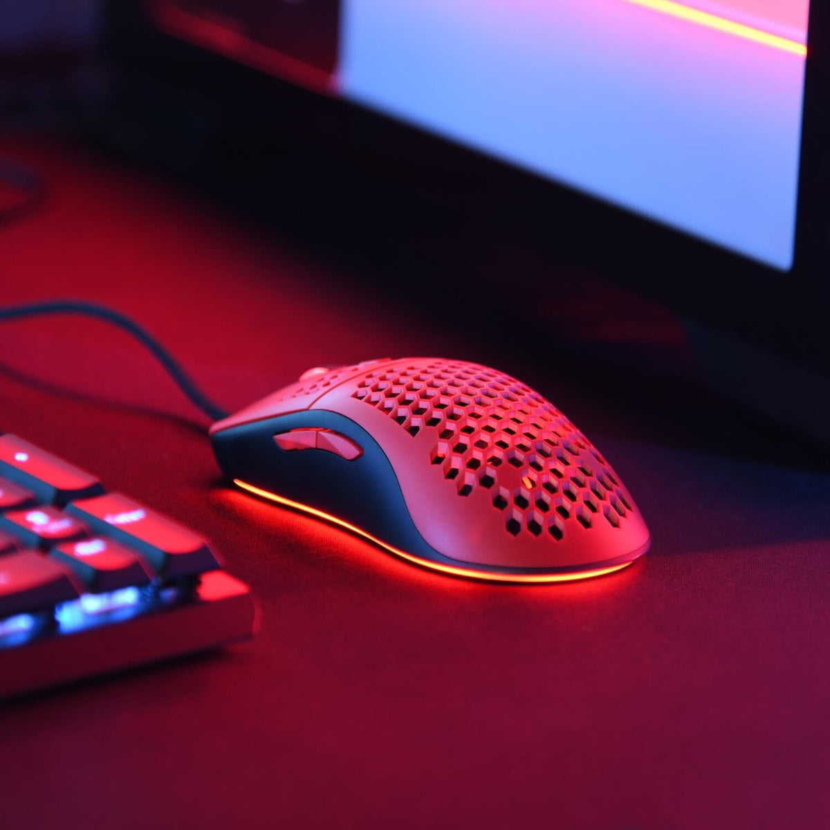 Arozzi Europe Favo Ultra Light Mouse with Pixart 3389 sensor, glowing red near keyboard.
