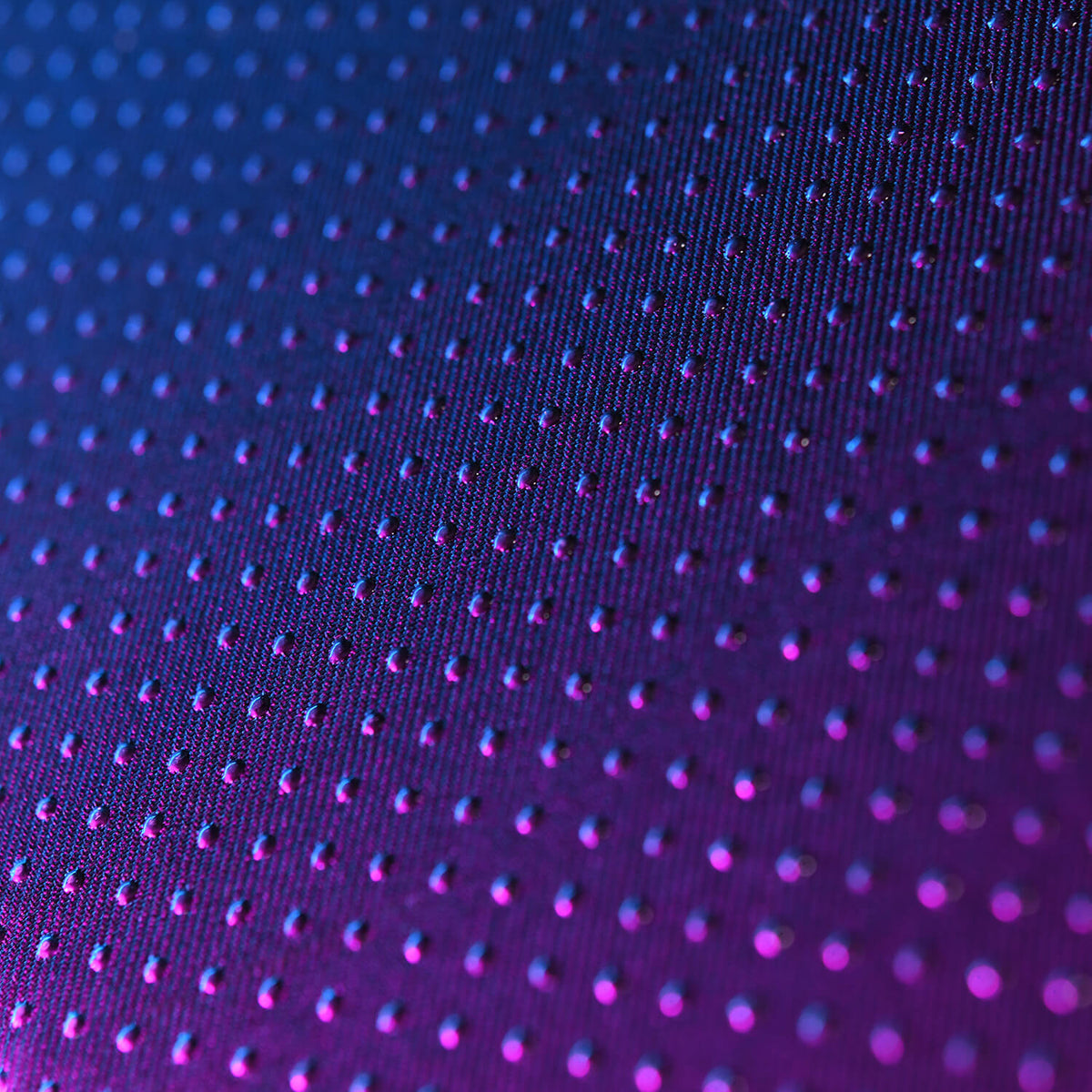 Purple and blue gradient surface with a grid of small raised dots.