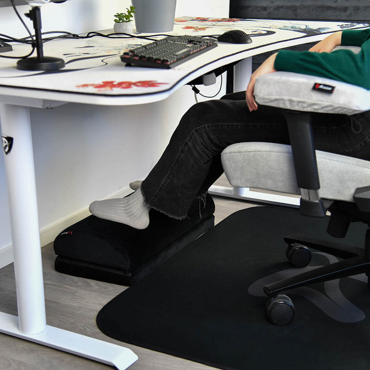 Person resting feet on Arozzi Europe Footrest under desk while sitting in an office chair.