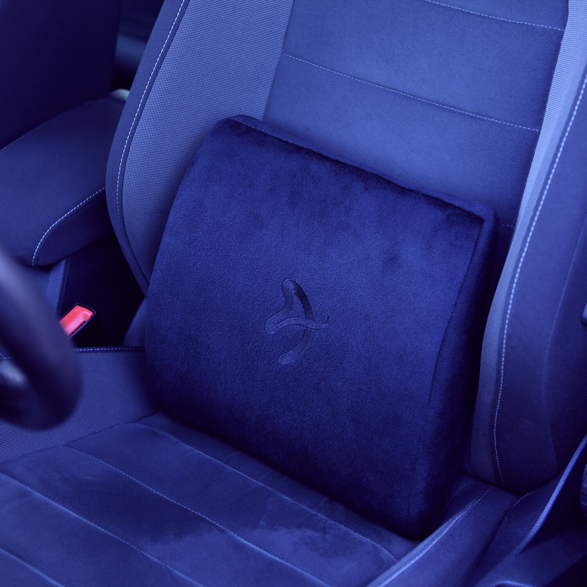Black memory foam back cushion on a car seat with a subtle embroidered logo in the center.