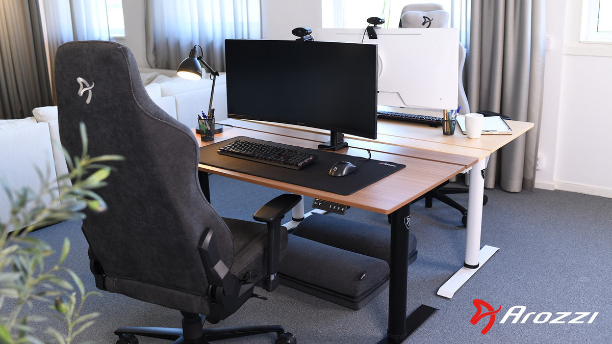 Modern gaming setup with dual monitors and chairs on a wooden desk, Arozzi logo in corner.