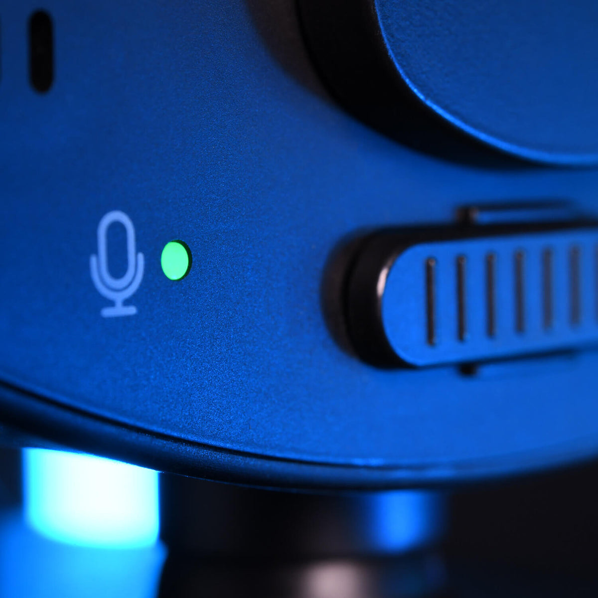 Close-up of a microphone with a glowing green indicator light, showing its powered on.