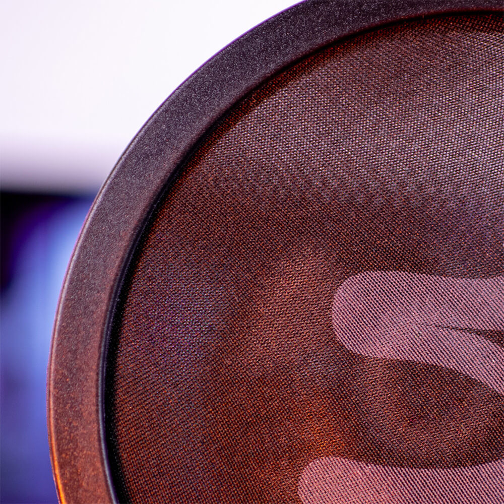 Close-up of a round mesh pop filter with part of a hand visible behind the mesh.