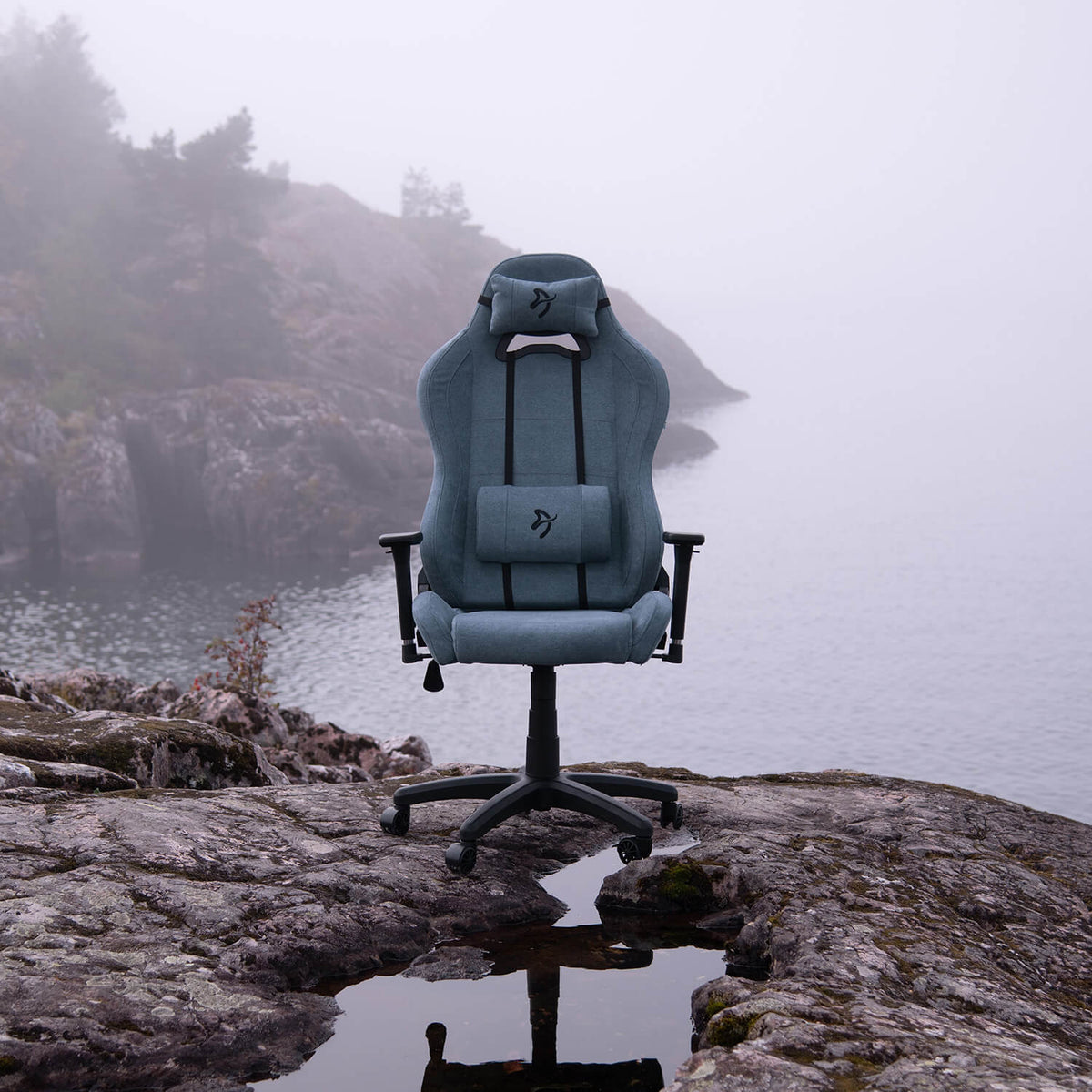 Arozzi Europe’s Torretta Soft Fabric chair stands on rocks near misty water and cliffs.