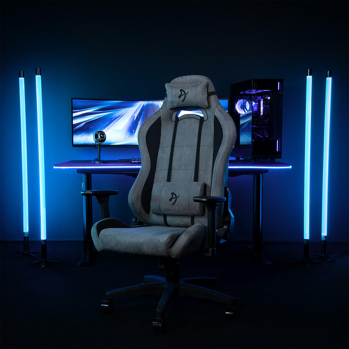 Arozzi Europe’s Torretta Supersoft chair sits before a PC setup with blue LED lighting.