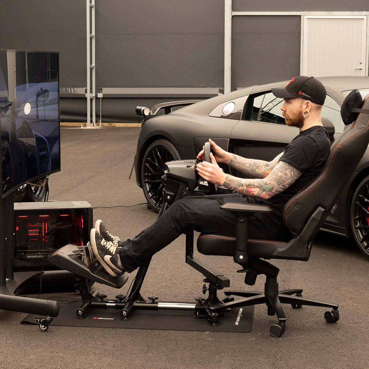 Arozzi Europe Velocità Racing Simulator Stand with steering wheel setup next to a sports car.
