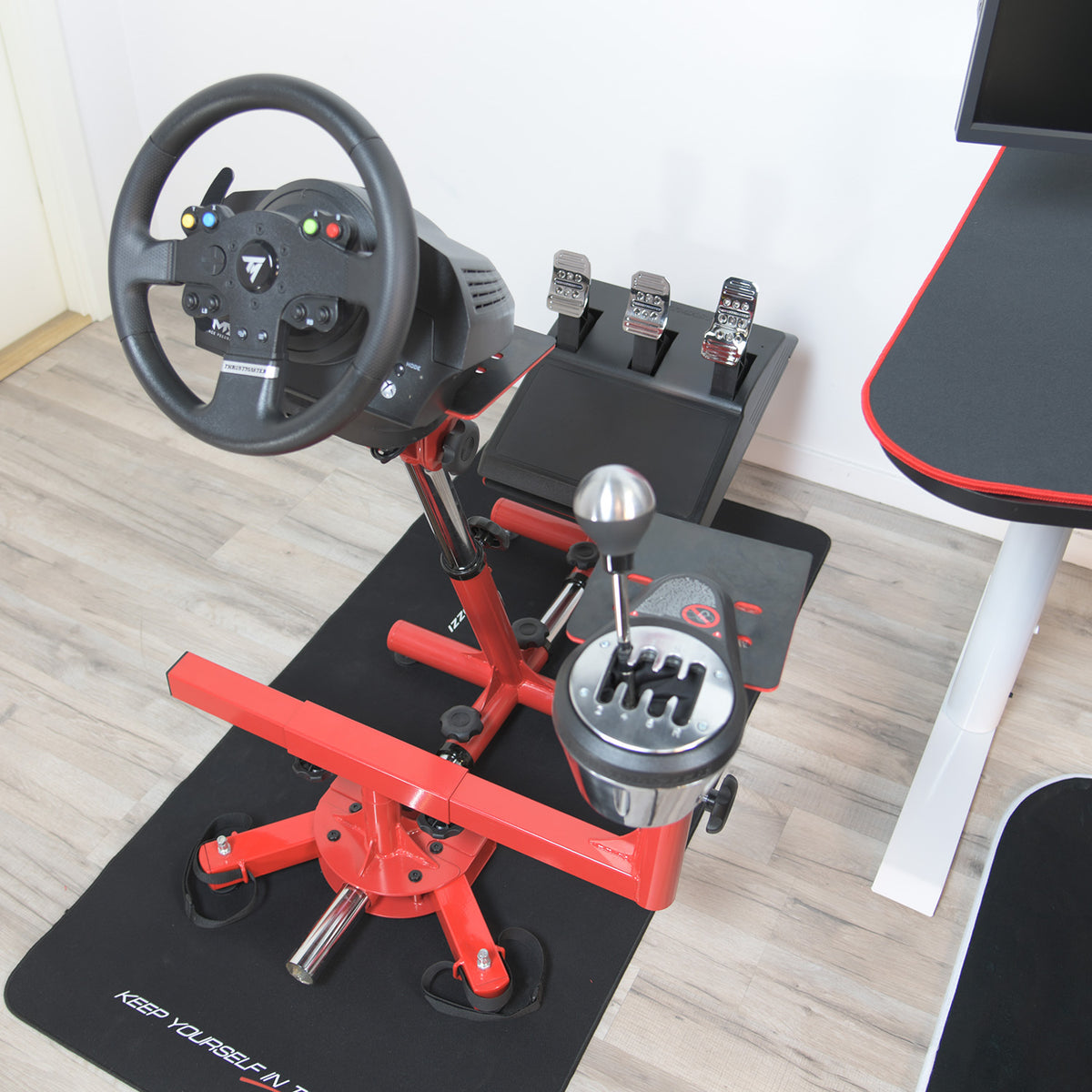 Arozzi Velocità Racing Simulator Stand with wheel, pedals & shifter on wooden floor.