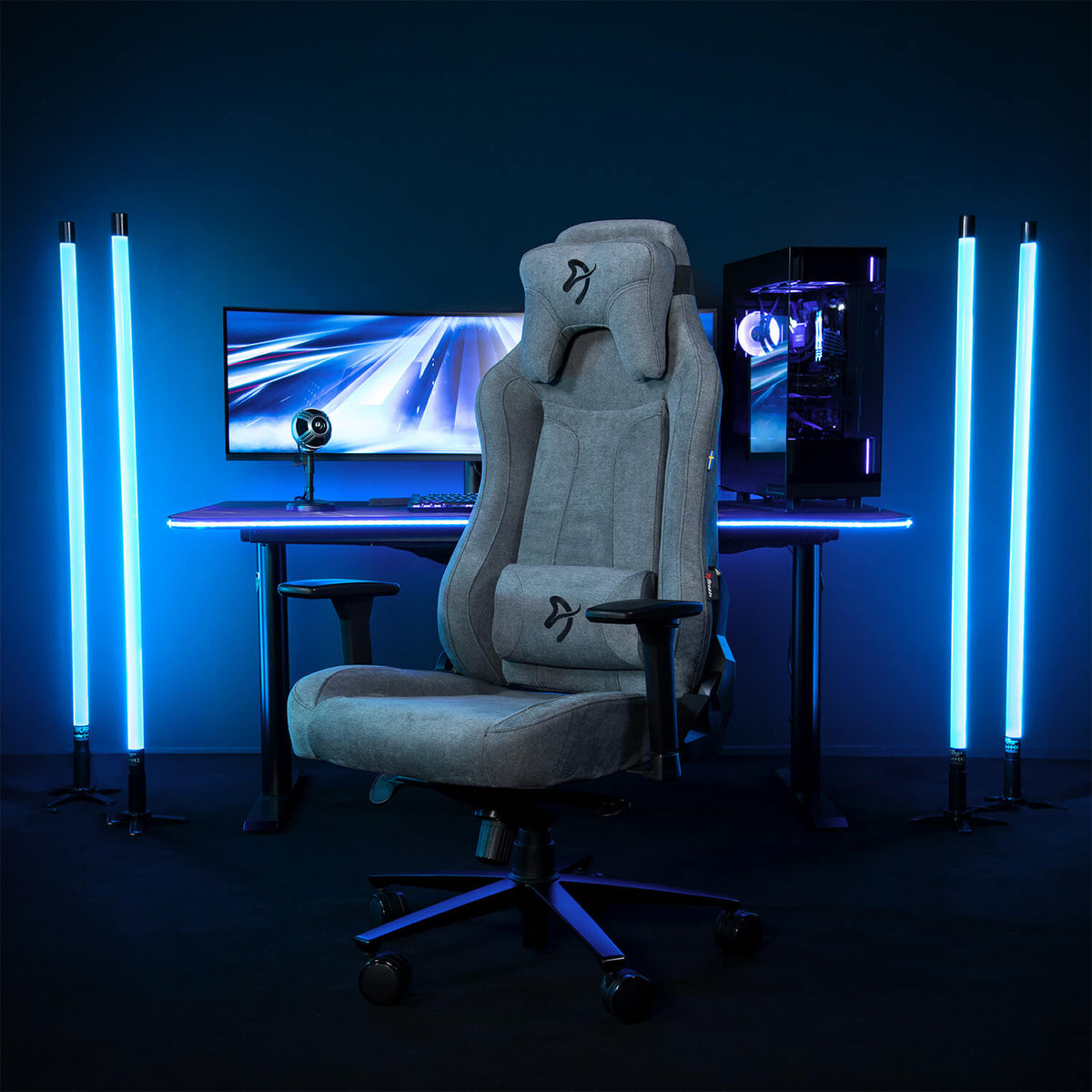 Arozzi Europe Vernazza Soft Fabric chair at a desk with monitors, neon lights, and a PC.