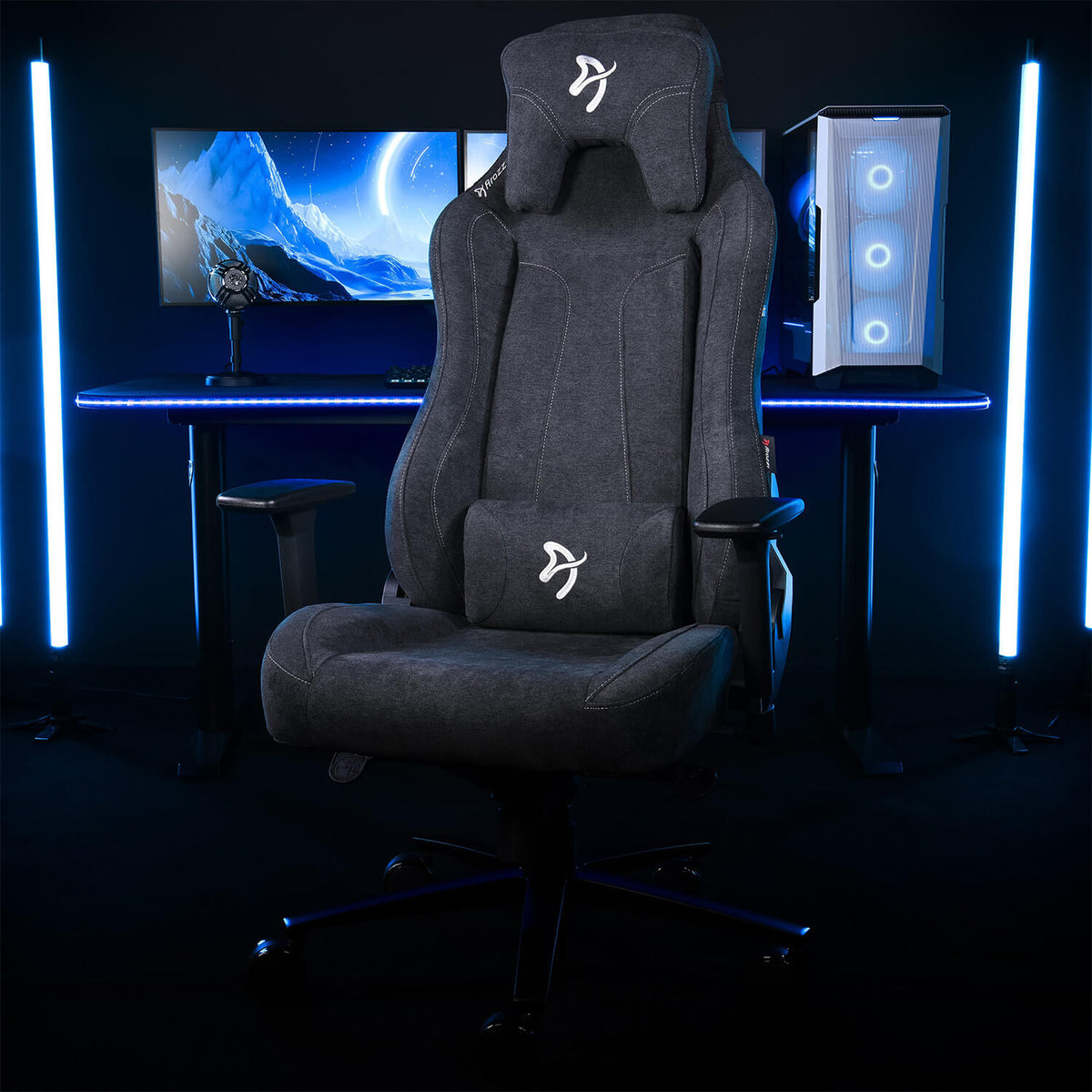 Arozzi Europe Vernazza Soft Fabric chair by a desk with PC, monitor & LED lights in dark room.