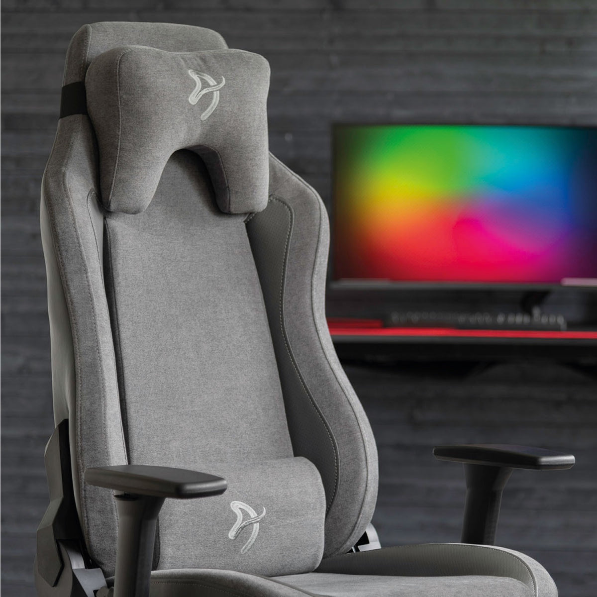 Arozzi Europe Vernazza Vento gray gaming chair with headrest; rainbow monitor blurred in back.