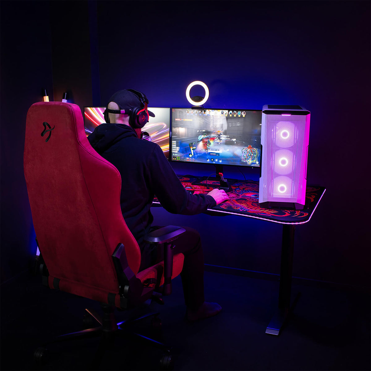 Gamer at dual monitors in an Arozzi Europe Vernazza Supersoft chair with LEDs and memory foam.