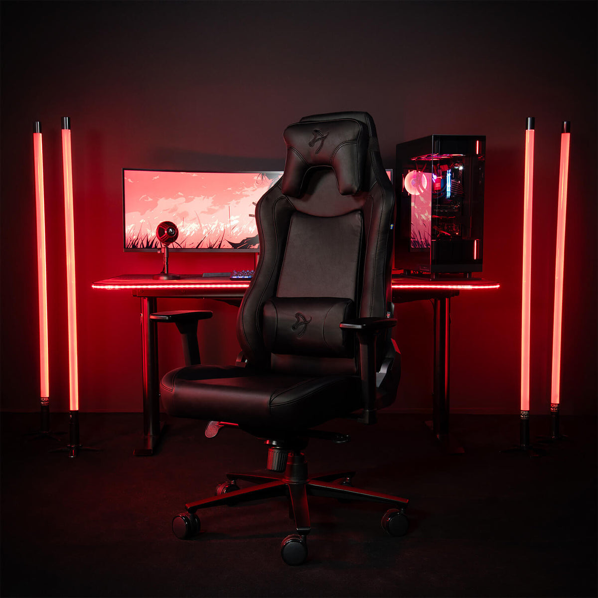 Arozzi Europe Vernazza SoftPU chair in front of a desk with red LED lights and monitors.