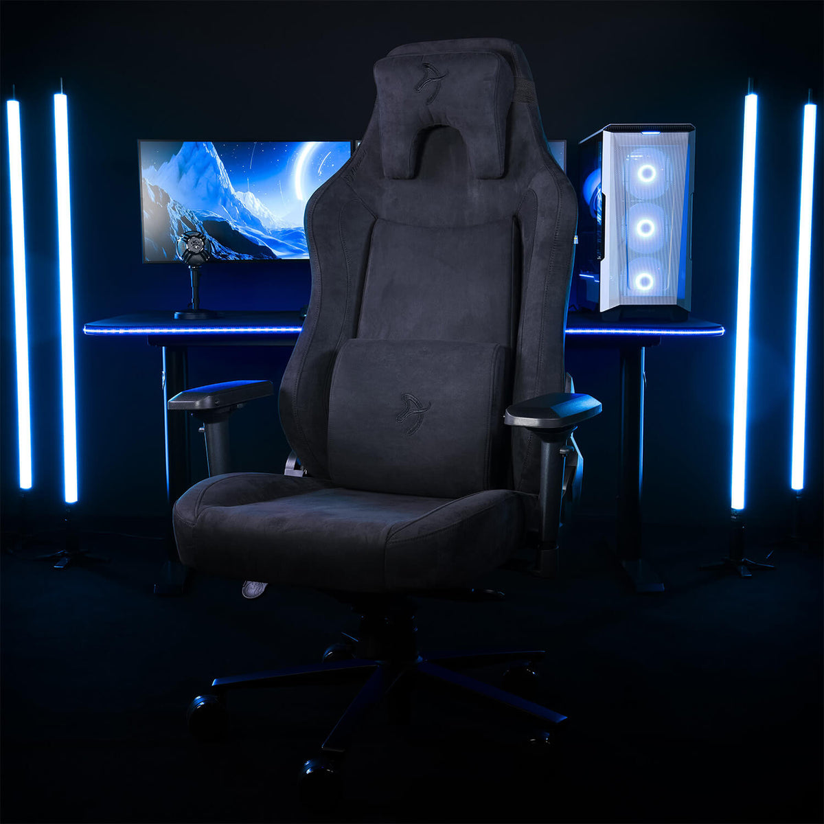 Arozzi Europe Vernazza XL Supersoft gaming chair at a desk with PC, monitor, and blue LEDs.