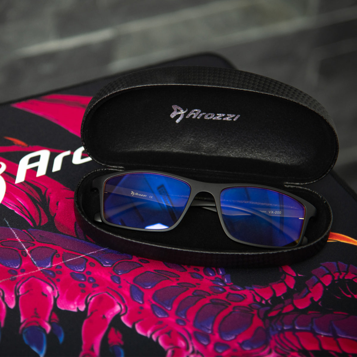 Arozzi Europe Visione VX-200 glasses in black case on colorful pad—perfect for computer use.