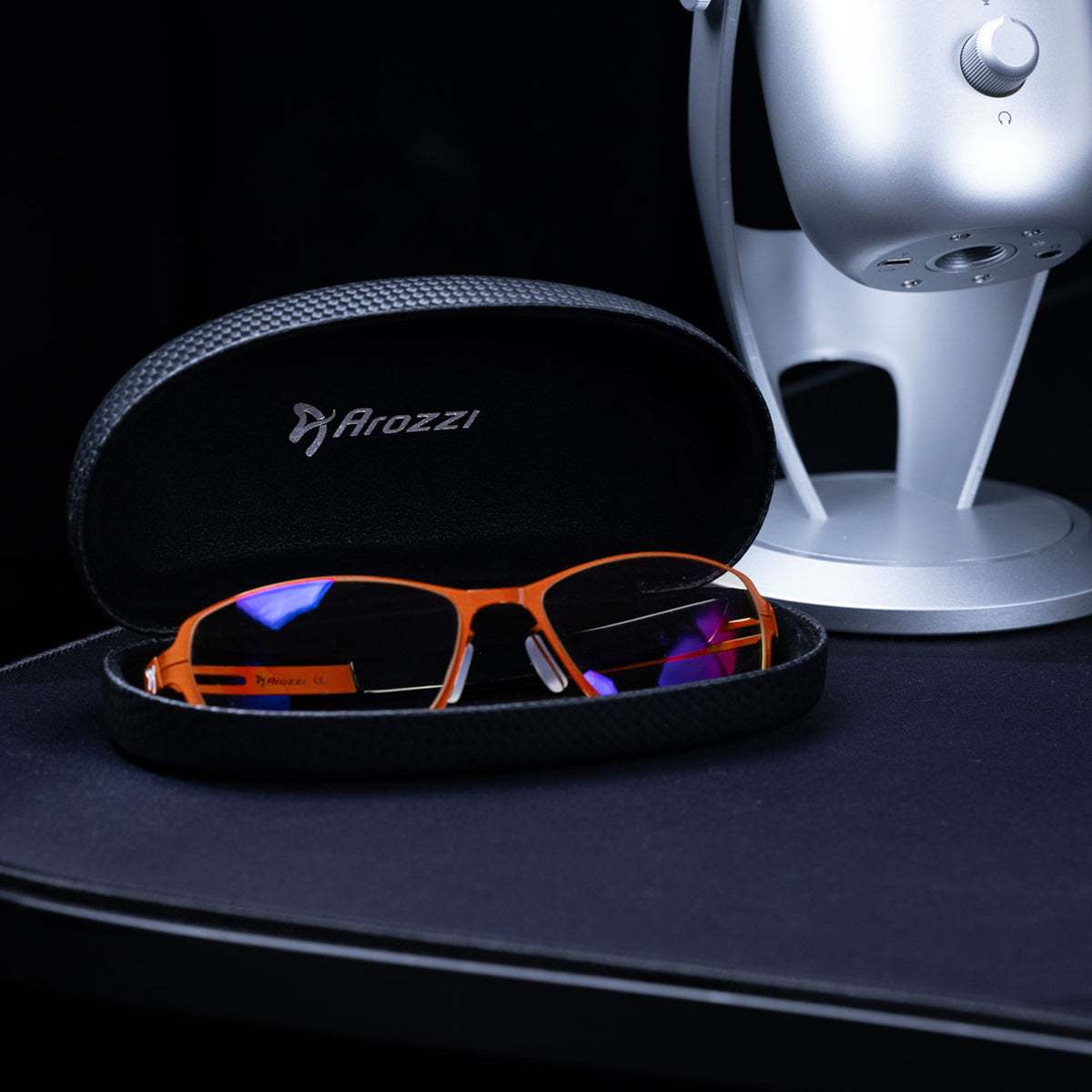 Visione VX-500 blue light glasses by Arozzi Europe, in case next to a silver mic for computer use.