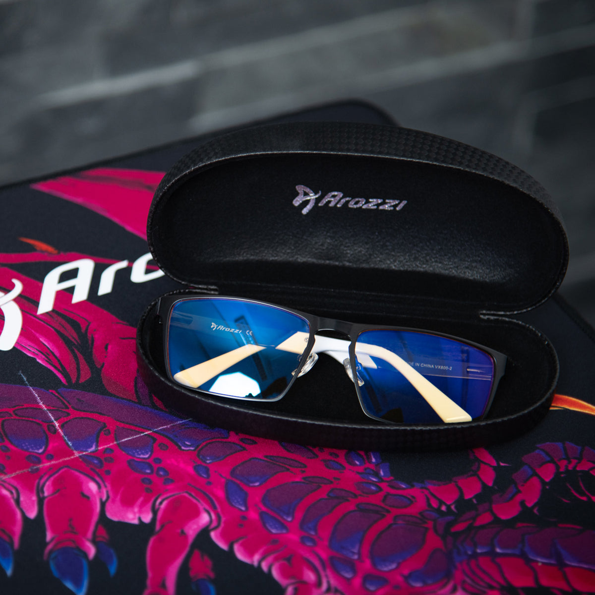 Visione VX-800 by Arozzi Europe in an open case on a mouse pad offers blue light protection.