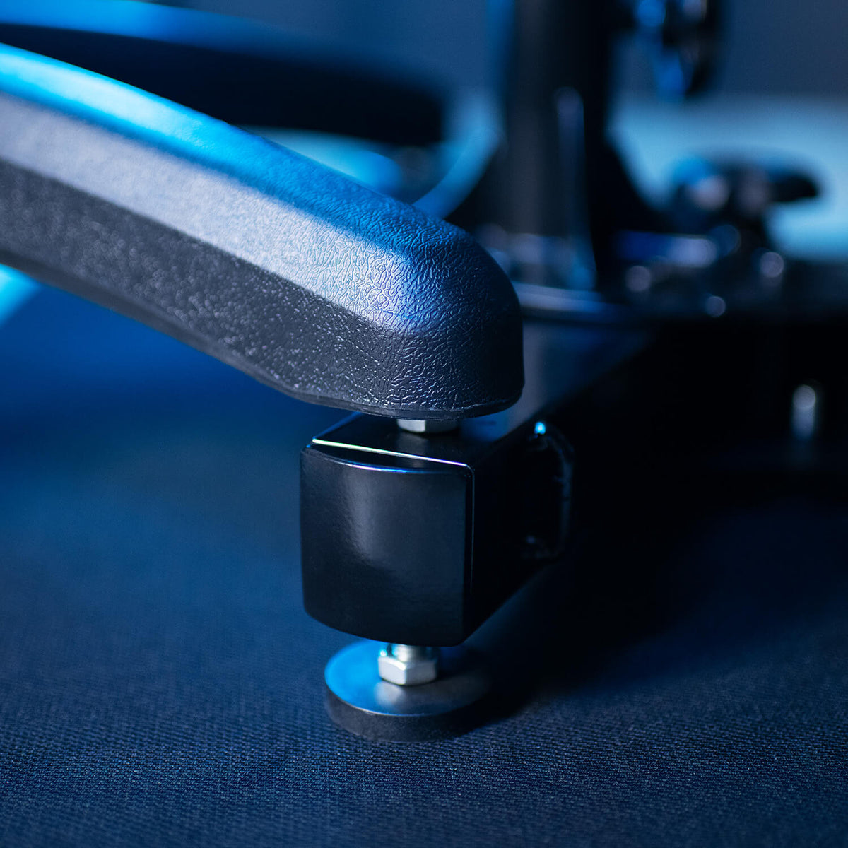 Close-up of an office chair armrest and adjustment mechanism, lit with blue lighting.