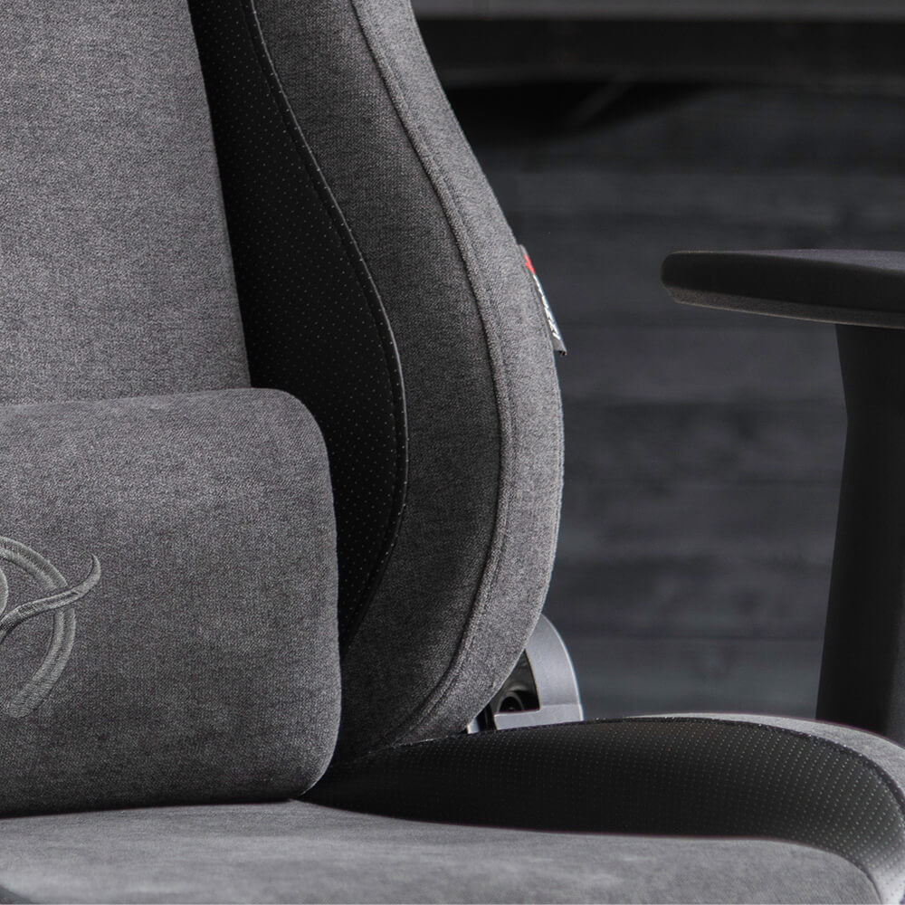 Close-up of a gray ergonomic office chair with visible armrest and cushion.