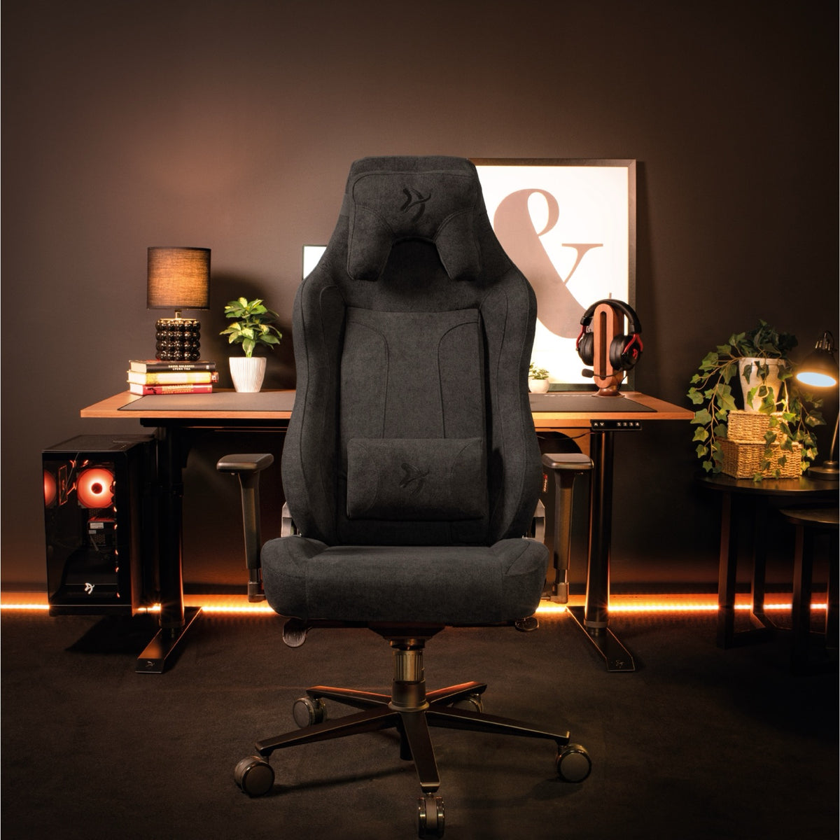 An Arozzi Europe Vernazza XL Soft Fabric chair stands before a desk with warm lighting.