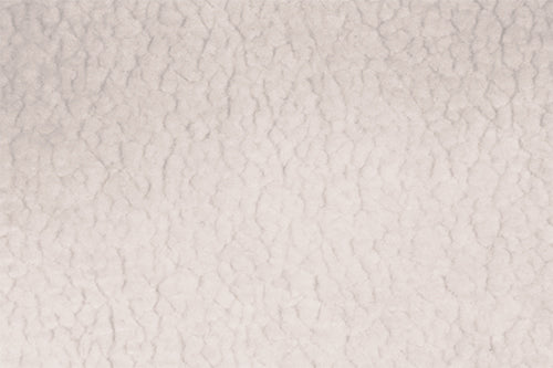 Light beige, textured surface with irregular, cracked patterns resembling parched earth.