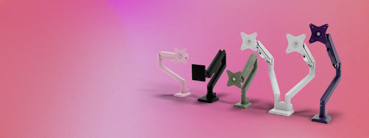 Five colorful monitor arms are displayed on a pink gradient background, lined up in a row.