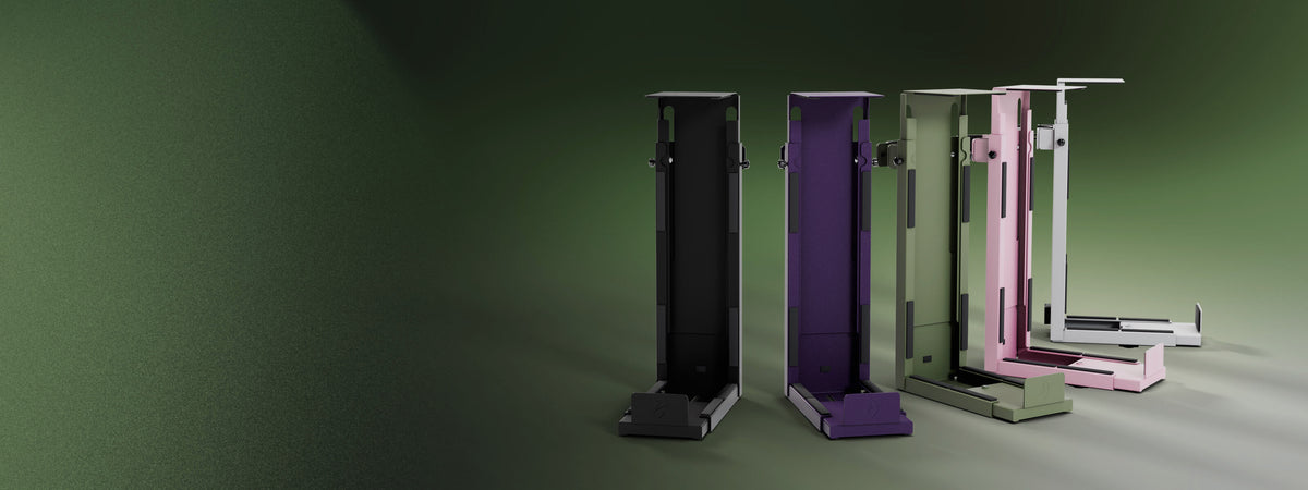 Four tall, rectangular machines in black, purple, green, and pink on a green background.