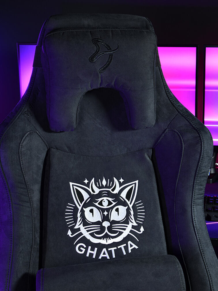 Black gaming chair with a cat logo and GHATTA, lit by purple lights in the background.